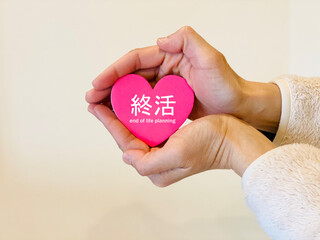 Fototapeta premium ハートを両手で包む女性の手_終活文字入り
