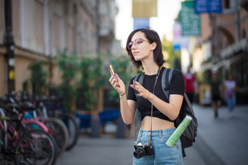 Tourist woman on the street holding phone.