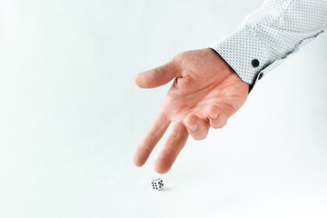 hand throws dice on white background with copy space.