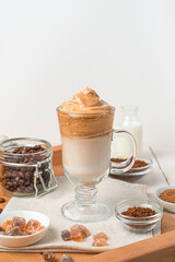 Dalgona coffee with whipped foam and ice on a white background.