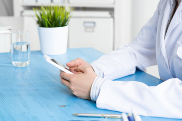 Close up of doctor hands holding mobile phone