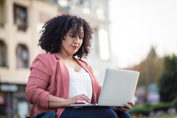Obraz na płótnie Canvas Business woman in the street using laptop.
