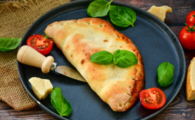 Home made italian calzone vegetarian  pizza with  tomatoes, mozzarella and parmesan cheese and fresh basil 