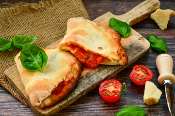 Home made italian calzone vegetarian  pizza with  tomatoes, mozzarella and parmesan cheese and fresh basil 