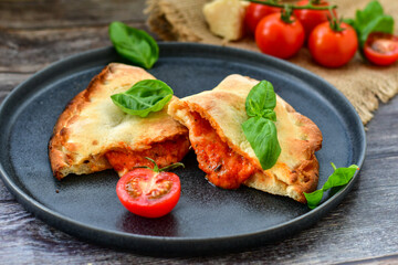 Home made italian calzone vegetarian  pizza with  tomatoes, mozzarella and parmesan cheese and fresh basil 