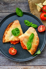 Home made italian calzone vegetarian  pizza with  tomatoes, mozzarella and parmesan cheese and fresh basil 