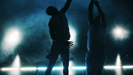 Slow motion of sportsmen fighting for a basketball in the dark