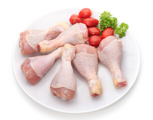 Raw chicken legs on a white plate 