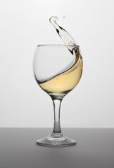 Wineglass with white wine with splash