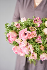 Beautiful bouquet of pink anemones in woman hand. the work of the florist at a flower shop. A small family business