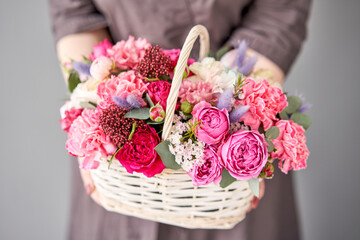 Small flower shop and Flowers delivery. Flower arrangement in Wicker basket. Beautiful bouquet of...