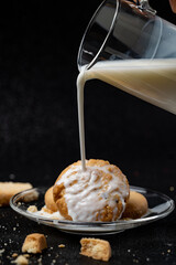 Cookies being topped with milk.
