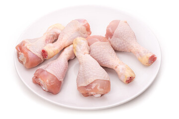 Raw chicken legs on a white plate 