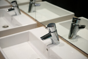 Reflection in the mirror of the tap and sink in the athletes' locker room.