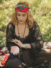 Gypsy soul... Boho woman with Tarot cards, candles and magic ball at field, lifestyle, predicting,...