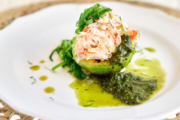 Crab salad tartare. Fresh Crab, avocado and pesto sauce with red caviar on a plate. Selective focus