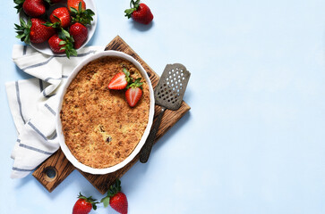 Crumble with strawberries on a benton background. View from above.
