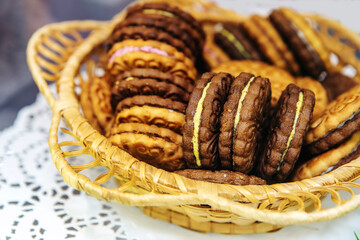 Round cookies with filling. Wheat confectionery in a wicker dish. Close-up