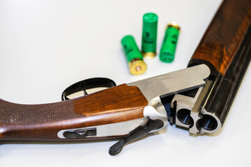 Fragment of a double-barreled shotgun and cartridges on a white background. Close-up. Selective...