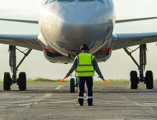 Ground Crew Signaling To Airplane On Wet Runway