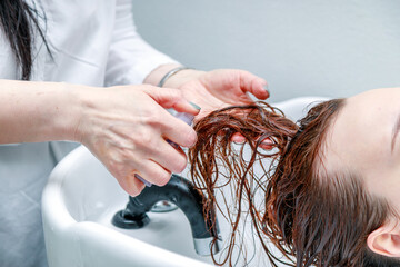 Naklejka premium Stylist washes the girl's head. High quality photo