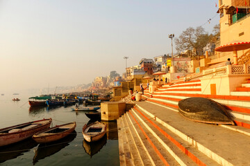 India, Varanasi Ganges river ghat with ancient city architecture as viewed from a boat on the river...