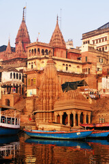 India, Varanasi Ganges river ghat with ancient city architecture as viewed from a boat on the river...