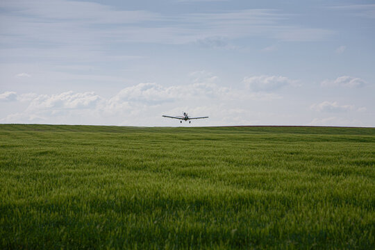 Avi&oacute;n sobrevolando y fumigando cultivo de cebada