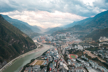aerial of the city near the river and mountains 
