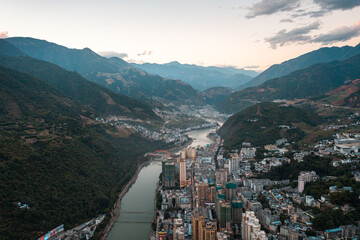 Fototapeta na wymiar aerial of the city near the river and mountains 