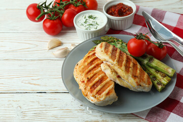 Concept of tasty eating with grilled chicken on white wooden table