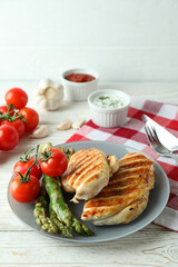 Concept of tasty eating with grilled chicken on white wooden table