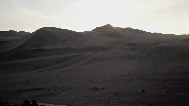 Huacachina Oasis encircling Sand Desert Dunes at Sunrise, Peru - Aerial
