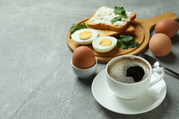 Concept of tasty breakfast with boiled eggs on gray textured table