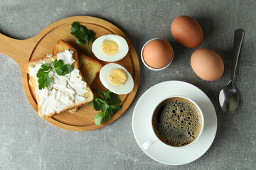 Concept of tasty breakfast with boiled eggs on gray textured table