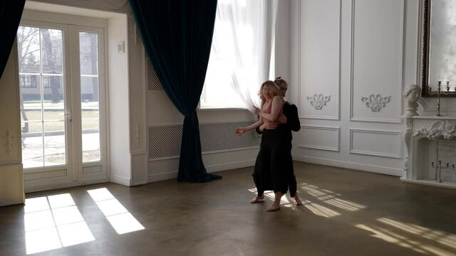 couple of young dancers are dancing and rehearsing dance performance in hall, modern choreography