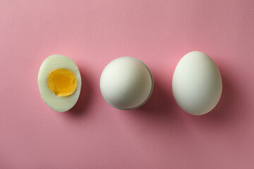 Tasty boiled eggs on pink background, top view