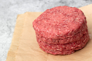 Raw beef burgers stacked on a brown paper bag. Environmentally friendly packaging for recycling