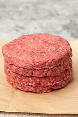 Raw beef burgers stacked on a brown paper bag. Environmentally friendly packaging for recycling