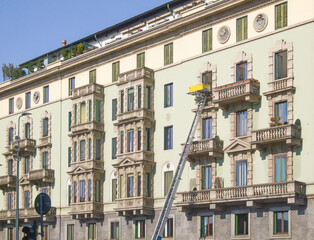 moving platform in front of the Art Nouveau facade of a building carries out a move.Milano,Lombardy,Italy.