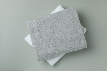 Clean folded towels on gray background, top view