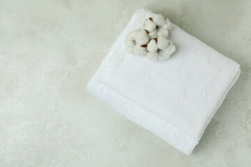 Clean folded towels with cotton on textured table