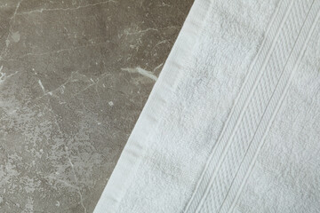 Clean white towel on gray textured background, space for text