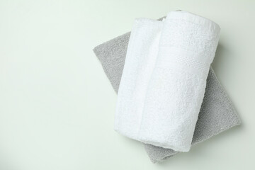 Clean folded towels on white background, space for text