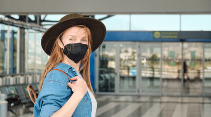 Fototapeta premium Young tourist woman wearing protective face mask in the airport. New normal for travel