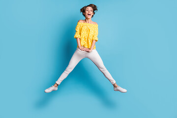 Fototapeta na wymiar Full size photo of cheerful excited young lady jump up air positive funky mood isolated on pastel blue color background