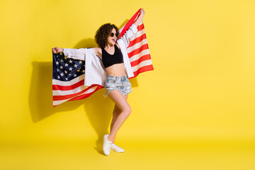 Full length body size photo of happy girl keeping american flag wearing sunglass isolated bright...