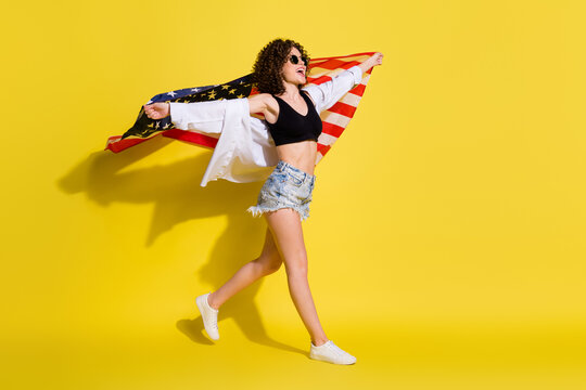 Full length body size photo of funky girl keeping american flag walking singing national anthem isolated bright color background