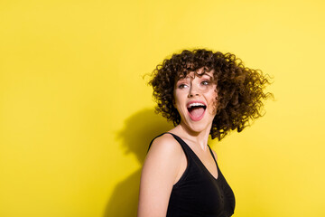 Profile portrait of nice wavy hairdo girl look back empty space open mouth wear black top isolated on yellow color background © deagreez