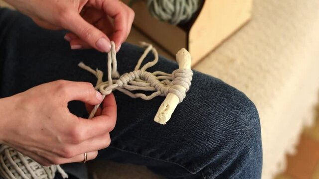 Close up of women's hands weaving macrame in a home workshop.Handmade concept.Slow motion.